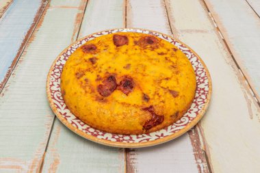 İspanyol omleti her iki tarafta da altın sarısı, görünürde yumuşak patatesler ve katmanlar arasında şeffaf soğan parçaları.