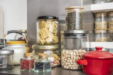 Cam kaplarda kurutulmuş malzemelerden oluşan kromatik bir mozaik, hardal sarısından nane yeşiline bir lezzet gökkuşağı yaratıyor.