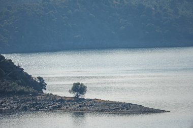 Uçurumların sakin sulara mükemmel bir şekilde yansıdığı dağ kanyonundaki rezervuarın panoramik görüntüsü