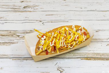 Tam Şili sosislisi, avokado püresi, doğranmış domates, lahana turşusu ve ev yapımı mayonez, özel sosisli çörekler ile servis ediliyor.