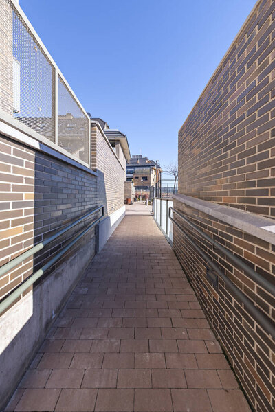 Outdoor gallery with exposed brick archways, compacted gravel flooring, and centuries-old wisteria on the columns.