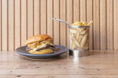 Bizonlu birinci sınıf burger, erimiş provolone peyniri, domates ve kızarmış brioche çörekleri arasında buzdağı salatası.