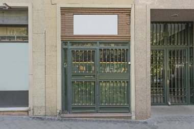 Geri kazanılmış ahşap kapısı olan küçük bir çatı katı girişi ve sokak seviyesinde havalandırmaya izin veren bir pencere.