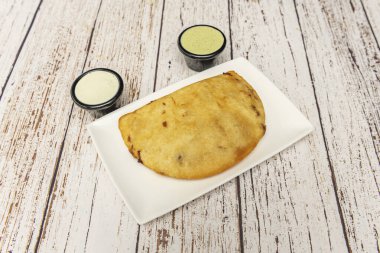 Kızarmış sarımsaklı salsa ve taze maydanoz eşliğinde kıtır hamurlu domuz derisi ve peynir.