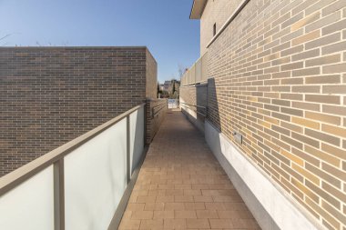 Endüstriyel tarzı tuğla duvarları olan açık hava koridoru, koloni fener ışıkları ve terasotta tencereleri.