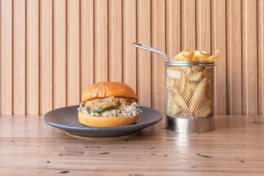 Yumuşak brioche ekmekli istiflenmiş hamburger, erimiş Amerikan peyniri, ve çıtır pastırma, hoşgörülü bir ziyafet.