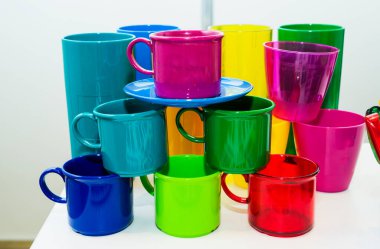 Beyaz arka planda çevre dostu malzemelerden yapılmış renkli plastik bardaklar. Çevre koruma kavramı.