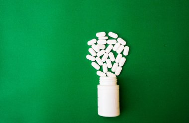 Haplar, haplar, yeşile izole edilmiş ilaç şişesi. Kopyalama alanı olan üst görünüm. İlaç eczanesi farmakoloji sağlık konsepti