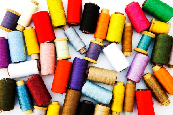 Multi-color silk thread coils on white background.