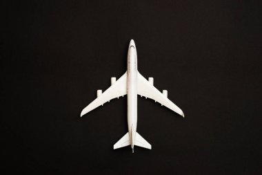 Siyah arka planda izole edilmiş beyaz bir uçak. Turizm ve seyahat kavramları.