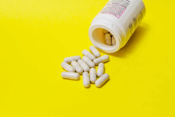 Таблетки Виливаються Білої Пляшки Жовтому Тлі Зробити Спеціальні Пропозиції Рекламу — стокове фото