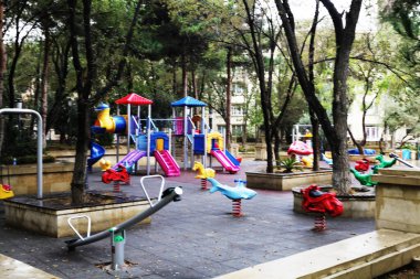 Parktaki renkli salıncaklı çocuk oyun evi.