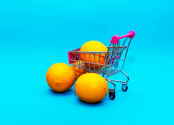 Pomeranče Železném Nákupním Vozíku Modrém Pozadí Obchodní Zdravé Stravovací Koncepce — Stock fotografie