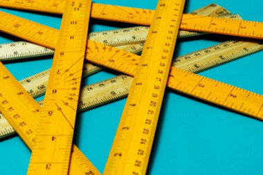 Kontrplak odasındaki metrik ve imparatorluk sistemindeki cetvelleri mavi arkaplanda kopya için kapat