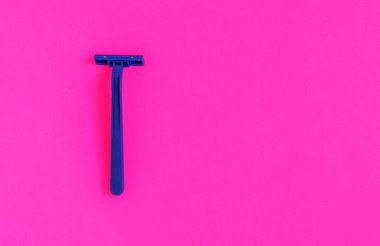 Pembe arka planda izole edilmiş kalıcı olmayan mavi plastik tıraş makinesi