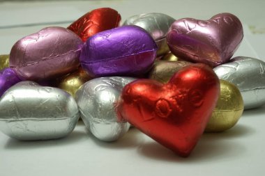 Beyaz arka planda çok renkli kalp şekilli çikolatalar. Kapat. Sevgililer Günü Konsepti.