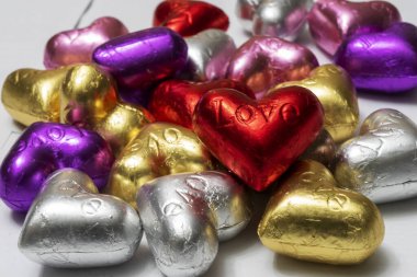 Beyaz arka planda çok renkli kalp şekilli çikolatalar. Kapat. Sevgililer Günü Konsepti.