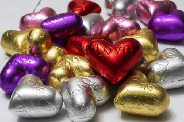 Beyaz arka planda çok renkli kalp şekilli çikolatalar. Kapat. Sevgililer Günü Konsepti.
