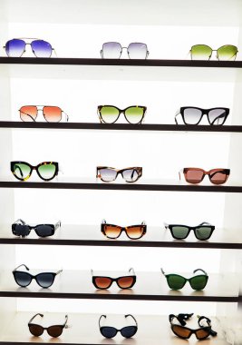 farklı, erkek ve kadın güneş gözlükleri mağazadaki raflarda satılık.