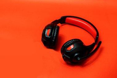 Kablosuz kulaklık, tam boy kulaklık, kırmızı arka planda siyah deri, kırpma yolu ile izole edilmiş.