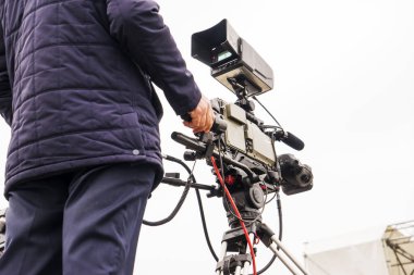 Şehir parkında video kamerasıyla çekim yapan bir kameraman.