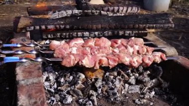 Domuz shashlyk bir mangal, closeup üzerinde hazırlanıyor. Adam şişler üzerinde domuz shashlik hazırlar.