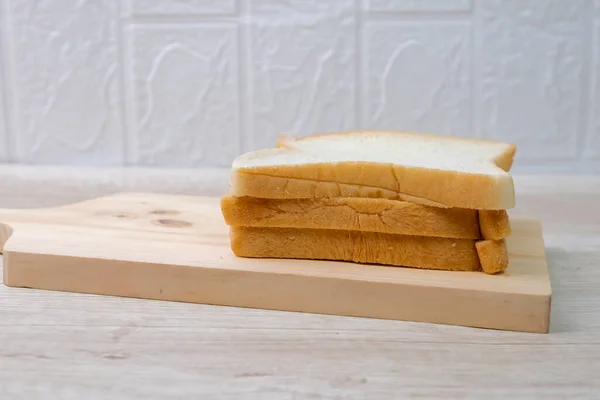 Scheiben Brot Auf Dem Schneidebrett Auf Dem Tisch — Stockfoto