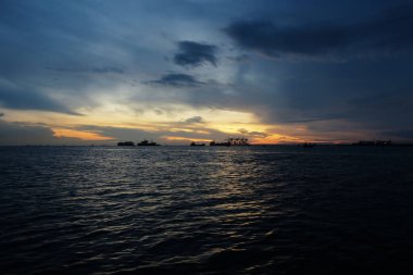 Bulutlu bir arka planda sabah güneşi yansıması. Tekne gölgesi ile gökyüzü görüntüsü