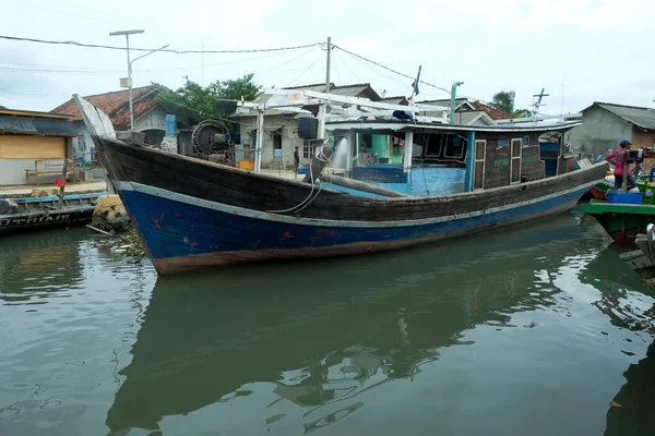 stock image Lampung, Indonesia 9 November 2022: Rows of fishing boats on the pier with shadow reflections in the water against a clear sky background