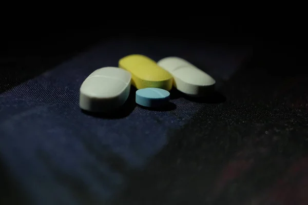 五颜六色的毒品黑暗背景下的药丸和胶囊 — 图库照片