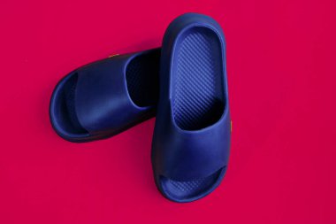 Eflatun bir arka planda izole edilmiş erkek lastik terlikleri.