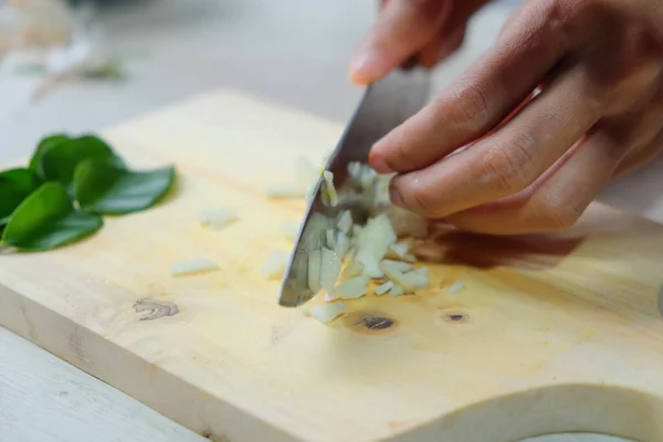 stock image Close-up of cook chopping onions on wooden cutting board