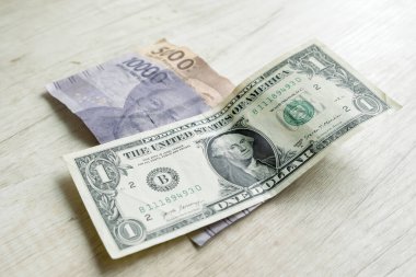 Bir dolarlık banknotlar ve 15,000 rupiah banknotlar. Döviz kurları kavramı