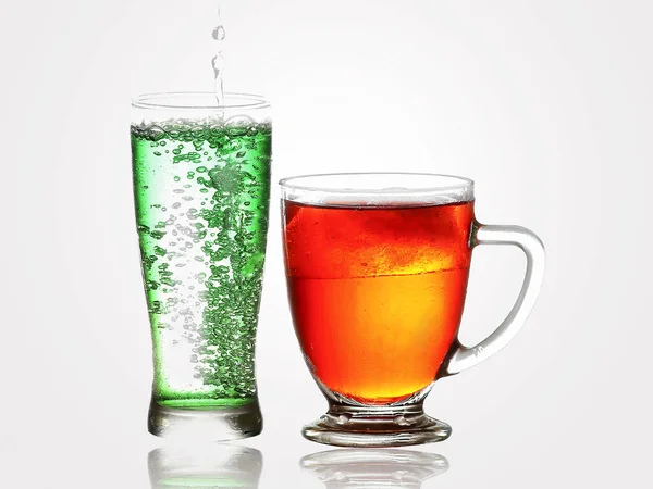 A glass of Splashing soda and bubbles and a glass of cola. Soft drink or Refreshment.