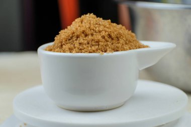 Brown sugar from natural cane juice on a unique white bowl
