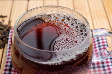 Closeup of herbal hot tea drink in glass on the table