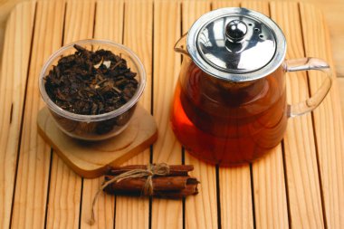 Hot herbal tea drink in glass composition with cinnamon on a wooden pallet