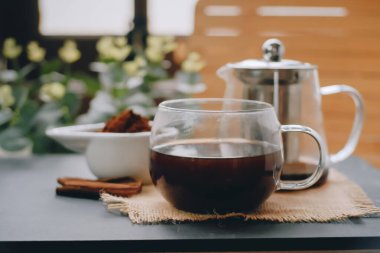 Black coffee and cinnamon sticks. Aromatic coffee from freshly ground coffee grounds.