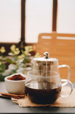 Black coffee and cinnamon sticks. Aromatic coffee from freshly ground coffee grounds.
