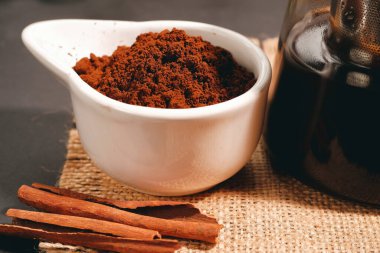 Black coffee and cinnamon sticks. Aromatic coffee from freshly ground coffee grounds