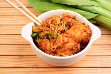 Beyaz kasede kızarmış hamur köftesi. Hardal yeşillikleri, fasulye filizleri ve baharatlı baharatlarla sotelenmiş ıslak hamur köftelerinden yapılır.