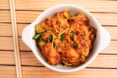 Beyaz kasede kızarmış hamur köftesi. Hardal yeşillikleri, fasulye filizleri ve baharatlı baharatlarla sotelenmiş ıslak hamur köftelerinden yapılır.