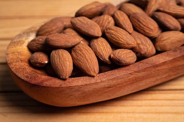 Stock image Almonds in a wooden bowl on a wooden table