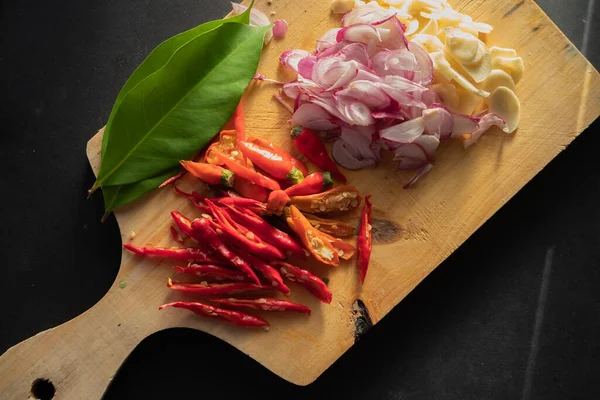 Sliced hot red chillies and shallots on a chopping board