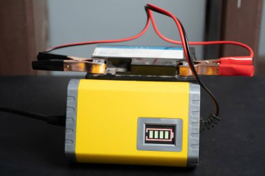 Motorsiklet aküsü şarj ediliyor, pil bakımı ve onarım konsepti