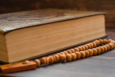 Tahta arka planda Tasbih ile İslam kutsal kitabı Kur 'an. Ramazan Kareem / Bayram Mübarek Kavramı