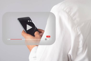 Video oynatıcı ikonu olan akıllı telefonu tutan bir erkek. çevrimiçi canlı video konsepti