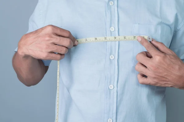 Man Mäter Bredden Bröstet Med Ett Måttband Grå Bakgrund — Stockfoto