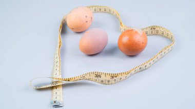 Tavuk yumurtası ve mezura. Beyaz arka planda sağlıklı beslenme konsepti.