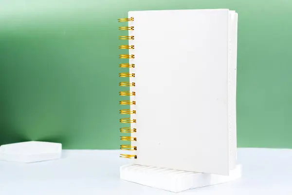 绿色背景上空白白色螺旋记事本 有空白处的笔记本 准备好你的信息 — 图库照片